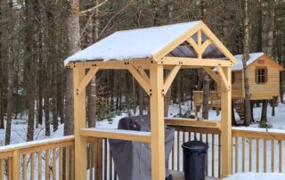 Covered gas barbecue grill on a patio with calming winter forest in the background as well as a freestanding treehouse with it’s own patio, at Muskoka Waterfront Cottage Retreat Covered gas barbecue grill on a patio with calming winter forest in the background as well as a freestanding treehouse with it's own patio, at Muskoka Waterfront Cottage Retreat